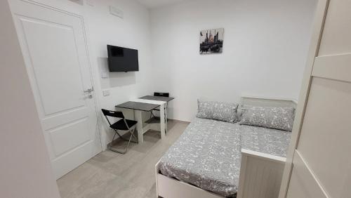 een kleine slaapkamer met een bed en een bureau bij Maison Ginevra in Pompei