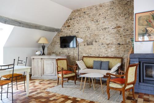 a living room with a couch and chairs and a fireplace at Le Moulin de Dannemarie in Dannemarie