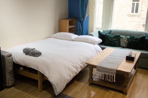 a bedroom with a bed and a couch at Cosy n Comfy Flat in Historic Heart of Edinburgh in Edinburgh