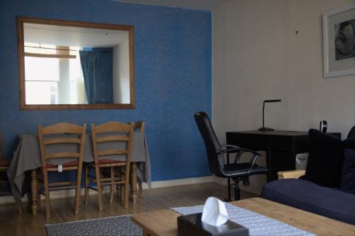 a living room with a table and a blue wall at Cosy n Comfy Flat in Historic Heart of Edinburgh in Edinburgh
