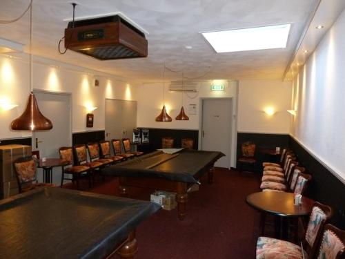 a dining room with tables and chairs and a ceiling at Hotel Centraal in Harlingen