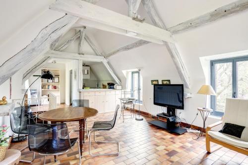 a living room with a table and a tv at Le Moulin de Dannemarie in Dannemarie