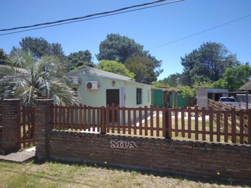 una casa con una valla de madera y una pared de ladrillo en Casa en La Aguada, en La Paloma