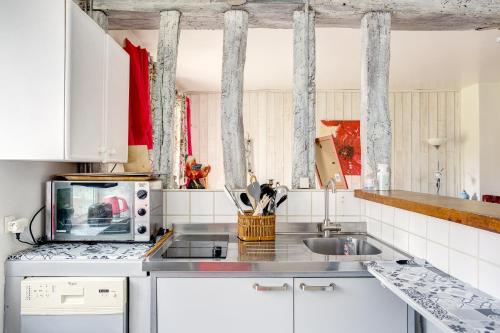 a kitchen with a sink and a microwave at Le Moulin de Dannemarie in Dannemarie