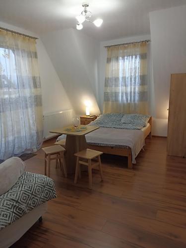 a bedroom with a bed and a table and windows at PRZY POTOKU -noclegi in Białka Tatrzańska
