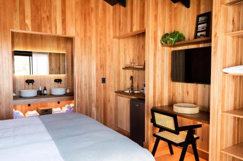 Dormitorio con cama, escritorio y TV en Aires Puros en José Ignacio