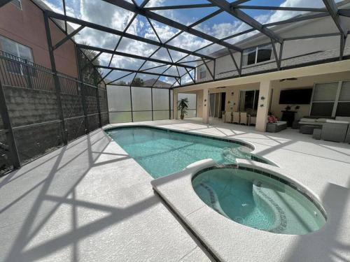 a swimming pool with a glass roof on a house at Emerald Island Private Pool Home near Disney in Kissimmee