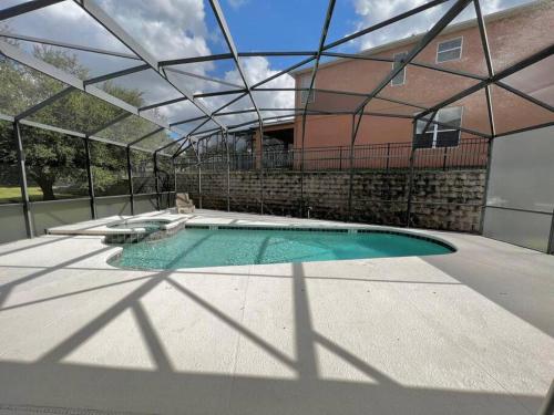 a swimming pool with a glass roof in front of a house at Emerald Island Private Pool Home near Disney in Kissimmee