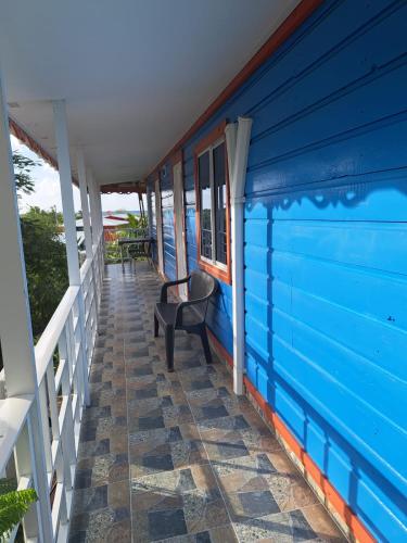 a blue house with a chair on the porch at Mary & Matt lodge in Providencia
