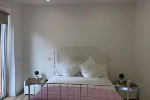 1 dormitorio con cama blanca y almohadas blancas en Agasweethome Rome Gemelli, en Roma