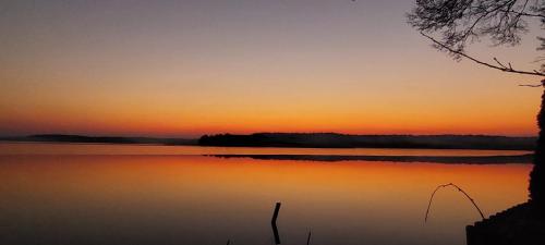 a sunset over a body of water at Biały Żagiel - Dom do wynajęcia Pluski in Pluski