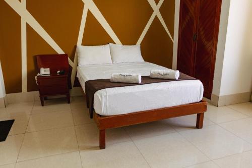 a bedroom with a bed with two towels on it at Hotel Plaza Teatro in Chiclayo