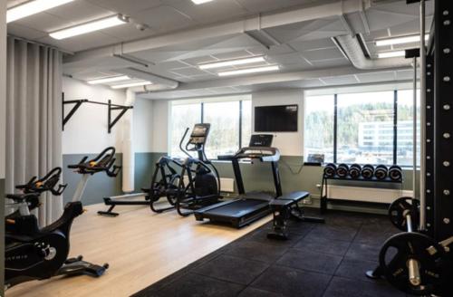 a gym with several treadmills and exercise bikes at Solna Property Apartment in Stockholm