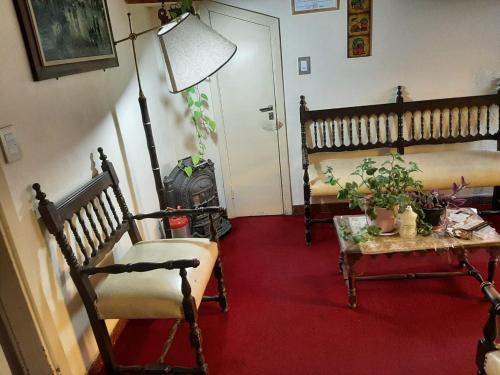 sala de estar con sillas, mesa y puerta en Hospedaje Legus en San Carlos de Bariloche