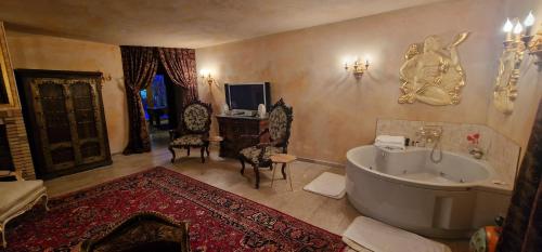 duża łazienka z wanną, stołem i krzesłami w obiekcie Faqra Palace w mieście Mzaar Kfardebian