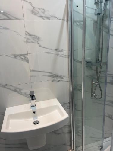 La salle de bains est pourvue d'un lavabo et d'une douche. dans l'établissement Belvue Serviced Apartment - Ealing Broadway, à Ealing