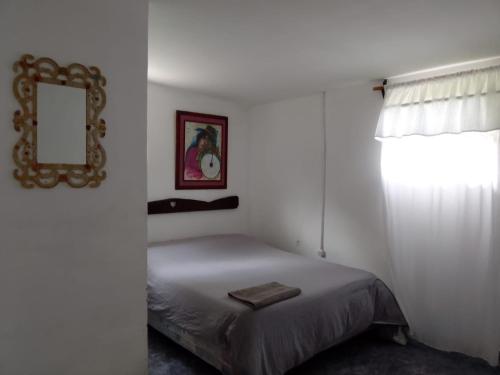 1 dormitorio con cama, espejo y ventana en Corralito Extremo en Rosario de Lerma