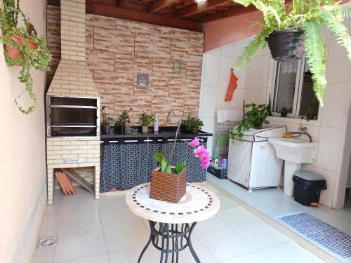 uma pequena cozinha com uma mesa e uma pia em Apartamento Boracéia Bertioga em Bertioga