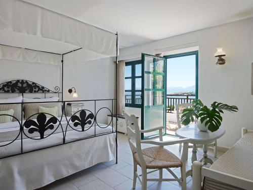 1 dormitorio con cama, mesa y comedor en Creta Maris Resort, en Hersonissos