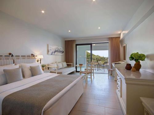 a bedroom with a large bed and a living room at Creta Maris Resort in Hersonissos