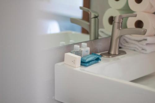 een wastafel in de badkamer met een kraan en een spiegel bij hotel vista valle in Tepic