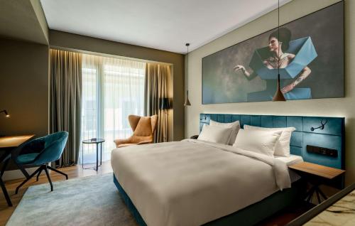 a hotel room with a large bed and a desk at Radisson Blu Aurum Hotel, Brasov in Braşov
