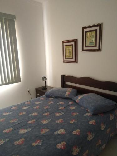 1 dormitorio con 1 cama con manta azul y ventana en Ótimo Apartamento na Praia dos Ingleses Gaivotas 70m do Mar, en Florianópolis