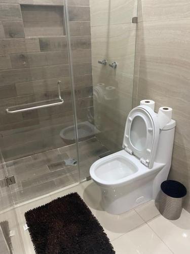 a bathroom with a toilet with a glass shower stall at Casa en privada culiacan. Stanza toscana in Culiacán