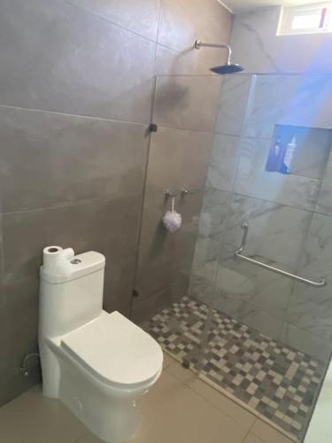 a bathroom with a toilet and a glass shower at Casa en privada culiacan. Stanza toscana in Culiacán