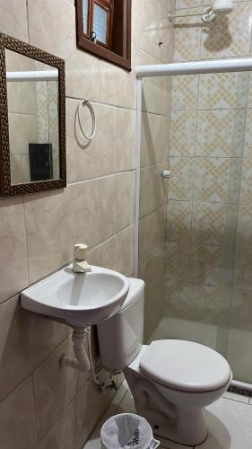y baño con aseo, lavabo y ducha. en Pousada Vale Do Aijalom, en Cabo Frío