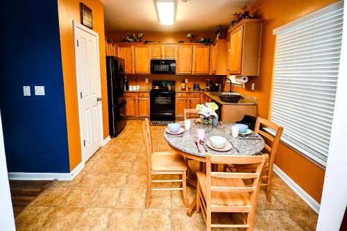 a kitchen with a table and chairs and a refrigerator at 4 - Bed home with Cali King Bed, 12 mins to DTWN in Atlanta