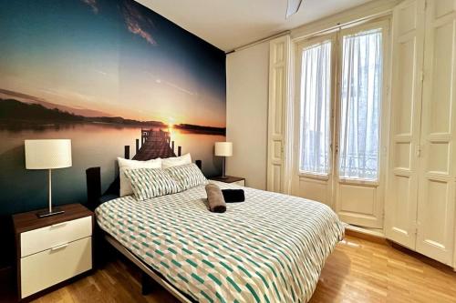 1 dormitorio con 1 cama con una pintura en la pared en Alojamiento entero centro: piso . CHUECA, en Madrid