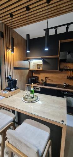 a kitchen with a table with a bottle on it at Design Apartment PLATINIUM SPA LUX 5 STAR "HAVANA" Completely PRIVATE Wellness & Spa FREE INCLUDED Sauna & Jacuzzi & Salt Wall & Fire place & 3D Ceilings & Business WiFi & NETFLIX & Keyless code entry & FULL SMART APP & SECURE 2 Parking place in Ćuprija