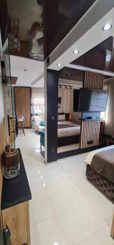 a bedroom with a bed and a living room at Design Apartment PLATINIUM SPA LUX 5 STAR "HAVANA" Completely PRIVATE Wellness & Spa FREE INCLUDED Sauna & Jacuzzi & Salt Wall & Fire place & 3D Ceilings & Business WiFi & NETFLIX & Keyless code entry & FULL SMART APP & SECURE 2 Parking place in Ćuprija