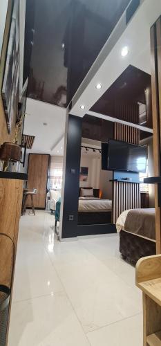 a large room with a bed and a television at Design Apartment PLATINIUM SPA LUX 5 STAR "HAVANA" Completely PRIVATE Wellness & Spa FREE INCLUDED Sauna & Jacuzzi & Salt Wall & Fire place & 3D Ceilings & Business WiFi & NETFLIX & Keyless code entry & FULL SMART APP & SECURE 2 Parking place in Ćuprija