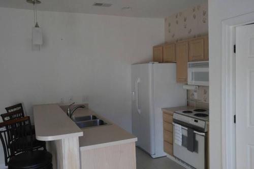 a kitchen with a white refrigerator and a sink at Two bedroom Sea Trail condo in Sunset Beach in Sunset Beach