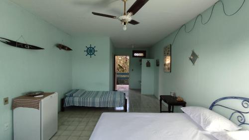 - une chambre avec un lit et un ventilateur de plafond dans l'établissement A Pousada., à Barra dos Coqueiros