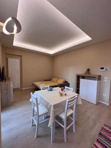 a living room with a table and chairs and a bed at CASA DANTE: Oneglia Centro-Marina-Spiagge (3 min) in Imperia