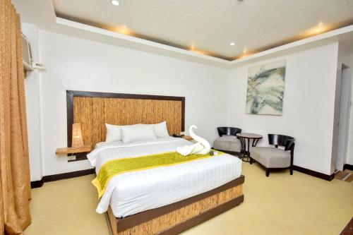 a bedroom with a large bed and a table and chairs at Bamboo Beach Resort & Restaurant in Boracay