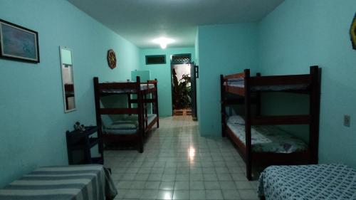 a room with two bunk beds and a hallway at Refúgio da Mangueira in Barra dos Coqueiros