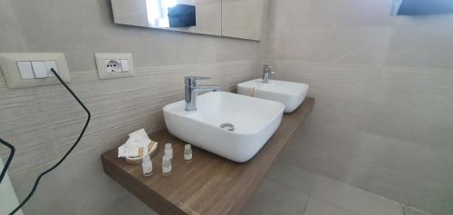 a bathroom with a white sink and a mirror at Vinea del Selvatico cascina agricola in SantʼAngelo deʼ Lombardi