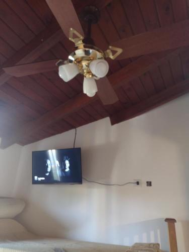 a ceiling fan with a tv on a wall at QUIRUS DORMIS in Villa Carlos Paz