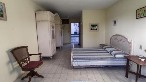 a bedroom with two beds and a chair in it at Refúgio da Mangueira in Barra dos Coqueiros