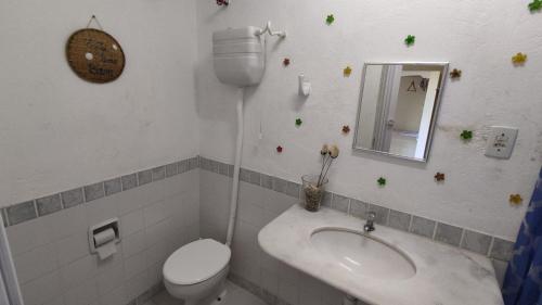 a bathroom with a sink and a toilet and a mirror at Refúgio da Mangueira in Barra dos Coqueiros