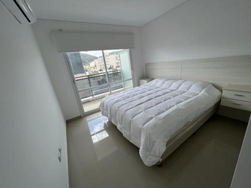 1 dormitorio con cama grande y ventana grande en Torre Leonardo I en Villa Carlos Paz