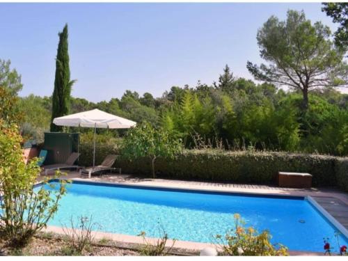 une piscine dans une cour avec un parasol dans l'établissement Holiday Home in France with Private Pool, à Seillans