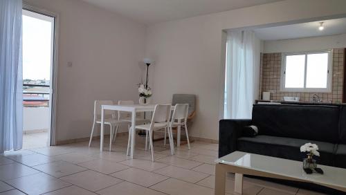 a living room with a couch and a table and chairs at Pentadaktylos Mountain view apt 2 bedroom in Nicosia