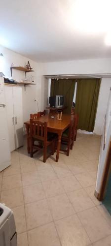 comedor con mesa, sillas y TV en Depto centro en Villa Gesell