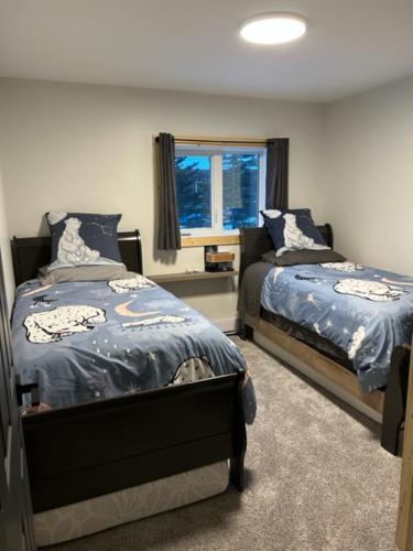 a bedroom with two beds and a window at Bears Den Guest House II in Churchill