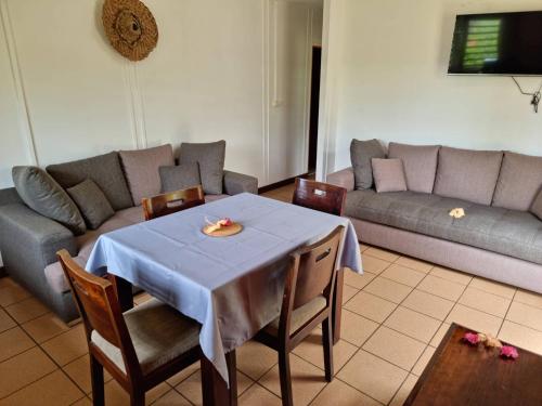 a living room with a table and a couch at Hotel Oasis de Kiamu in Lifou